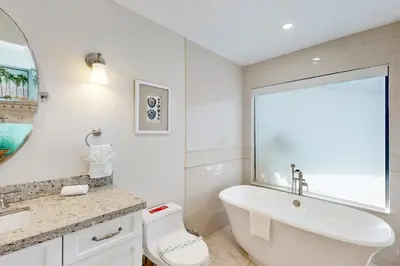 a white bathroom with a tub and a sink and a toilet at Middle River Lookout in Fort Lauderdale