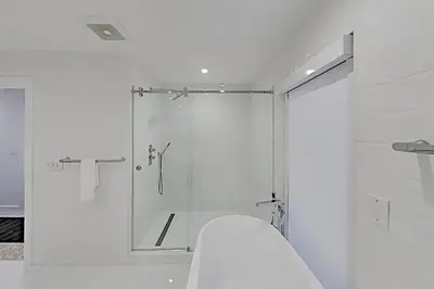 a white bathroom with a shower and a toilet at Designer Delight in Fort Lauderdale