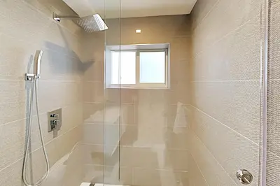 a bathroom with a shower with a glass door at Designer Delight in Fort Lauderdale
