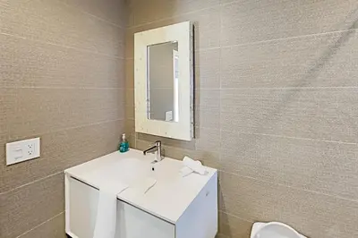 a bathroom with a white sink and a mirror at Designer Delight in Fort Lauderdale