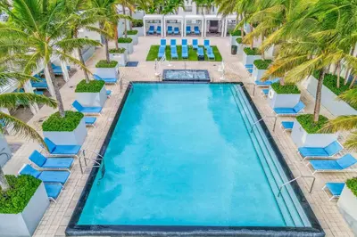 an overhead view of a pool with lounge chairs and palm trees at The Residency at Fort Lauderdale in Fort Lauderdale