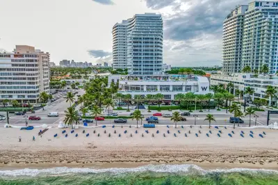 an aerial view of a beach in front of buildings at The Residency at Fort Lauderdale in Fort Lauderdale