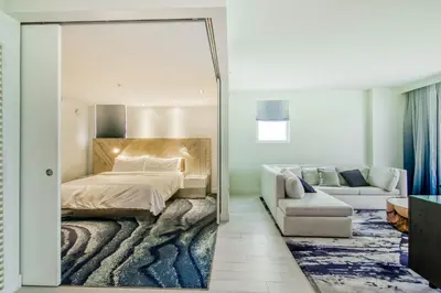 a bedroom with a bed and a couch and a mirror at The Residency at Fort Lauderdale in Fort Lauderdale