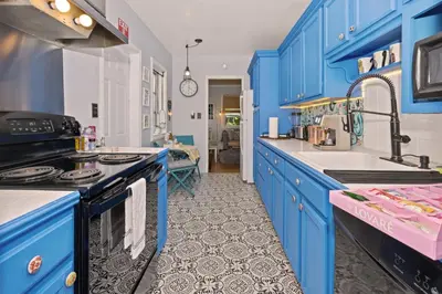 a kitchen with blue cabinets and a sink at Cozy Cottage Near Beach in Hollywood