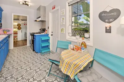 a kitchen with blue cabinets and a table in a room at Cozy Cottage Near Beach in Hollywood