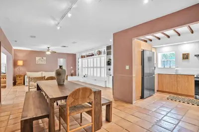 a kitchen and living room with a table and chairs at NEWLY RENOVATED POOL, HOT TUB, & EPIC BACKYARD in Fort Lauderdale