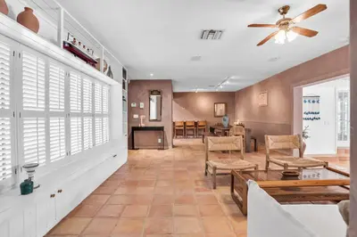 a living room with a ceiling fan and a table at NEWLY RENOVATED POOL, HOT TUB, & EPIC BACKYARD in Fort Lauderdale