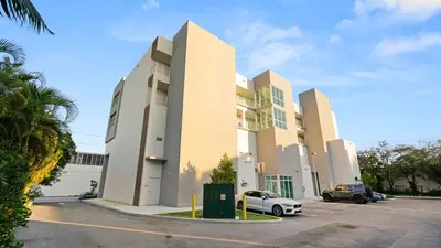 a building with a car parked in a parking lot at Lofts of Aventura in Miami