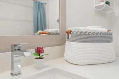 a towel basket sitting on a bathroom counter in front of a mirror at Lofts of Aventura in Miami