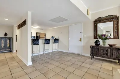 a living room with a kitchen and a mirror at NEW Amazing large 3BR direct oceanfront Penthouse On Ocean Drive!! in Miami Beach