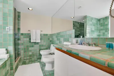 a bathroom with a sink and a toilet and a mirror at NEW Amazing large 3BR direct oceanfront Penthouse On Ocean Drive!! in Miami Beach
