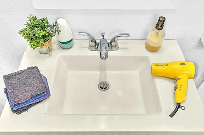 a white sink with a yellow blow dryer on it at Boutique One Bdrm Close To Aventura Mall & Beach in Hallandale Beach