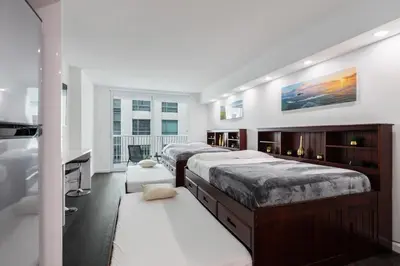 a large bedroom with two beds and a tv at Studios in Brickell with Pool, Gym, free parking and Game Room in Miami