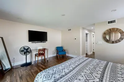 a bedroom with a bed and a flat screen tv at Mid-Century Modern Oasis in Miami