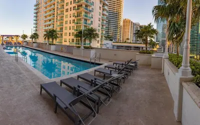 a hotel pool with chairs and palm trees and buildings at Luxury 1BD Apt in Downtown Brickell free parking in Miami