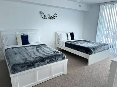 a white bedroom with two beds and a window at 1Bd Apt with Free Parking and Amazing View in Miami