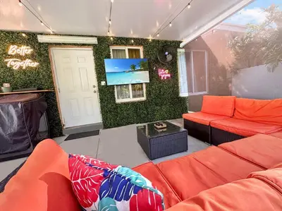a living room with orange furniture and a green wall at Escape GameRoom, BAR, BBQ, Spacious,KING Bed, All Luxury mattresses, Near Beach, 6 blocks away from Bars, Nite Clubs, Res, Shops in Miami
