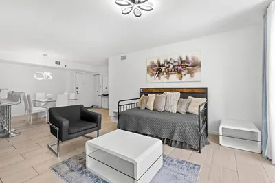 a bedroom with a bed and a chair and a table at Yacht Club Miami Suite 2 Bedroom and 2 Bathroom With Baby Crib & Free Parking in Miami