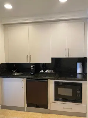 a kitchen with white cabinets and black counter tops at The Atlantic Hotel & Spa Condo in Fort Lauderdale
