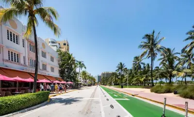 a street in front of a resort with palm trees at The Carlyle Oceanfront Luxe Condo Miami Beach in Miami Beach