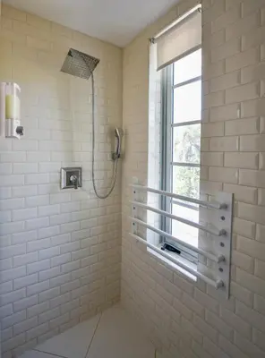 a shower in a bathroom with a window at The Carlyle Oceanfront Luxe Condo Miami Beach in Miami Beach