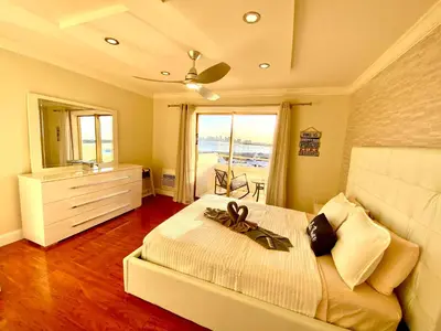 a bedroom with a bed with a dresser and a window at Deluxe waterfront one bedroom apartment with Miami Skyline view, free parking 5 mins drive to Miami Beach in Miami Beach