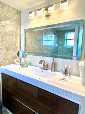 a bathroom with a sink and a large mirror at Modern waterfront apartment with Miami Skyline view, free parking 5 mins drive to Miami Beach in Miami Beach
