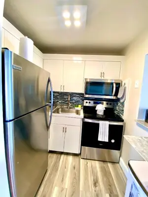 a kitchen with a stainless steel refrigerator and a sink at Modern waterfront apartment with Miami Skyline view, free parking 5 mins drive to Miami Beach in Miami Beach