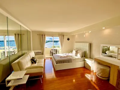 a living room with a bed and a couch at Modern waterfront apartment with Miami Skyline view, free parking 5 mins drive to Miami Beach in Miami Beach