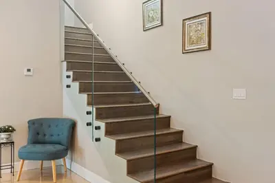 a stairway with a blue chair next to a stair case at Las Olas Villa with HEATED Salt Water Pool in Fort Lauderdale