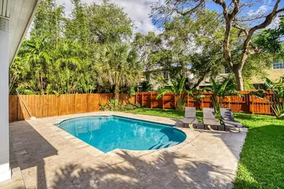 a swimming pool in a yard with a fence at Las Olas Villa with HEATED Salt Water Pool in Fort Lauderdale