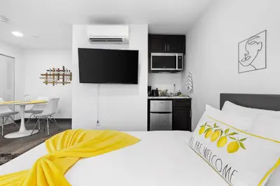 a bedroom with a large bed with a yellow blanket on it at Sunset Inn-South Miami in South Miami
