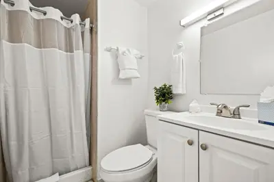 a white bathroom with a toilet and a sink at Sunset Inn-South Miami in South Miami