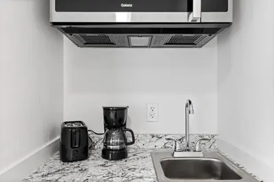 a kitchen counter with a sink and a blender at Sunset Inn-South Miami in South Miami