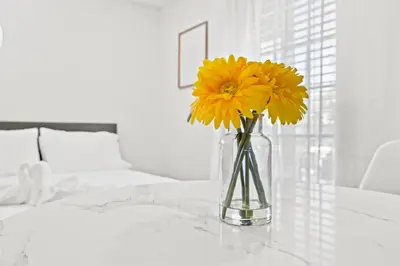 a vase filled with yellow flowers sitting on a table at Sunset Inn-South Miami in South Miami
