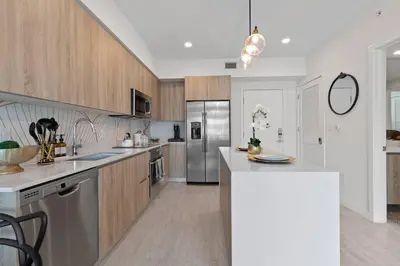 a kitchen with wooden cabinets and stainless steel appliances at LUXURY 1 BDRM/1B APT IN MIAMI DESIGN DISTRICT AREA in Miami
