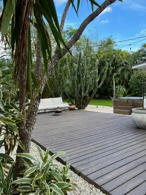 a wooden deck with a couch in a garden at Casa Terra Lumi - at lumicollection in Fort Lauderdale
