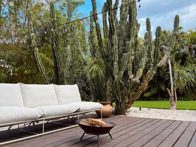 a white couch sitting on a wooden deck with cactus at Casa Terra Lumi - at lumicollection in Fort Lauderdale
