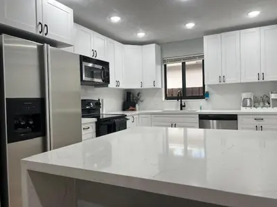 a kitchen with white cabinets and a large white counter top at 3 Bed - Sleeps 6 - Free Parking - 5 Mins to Beach in Hollywood