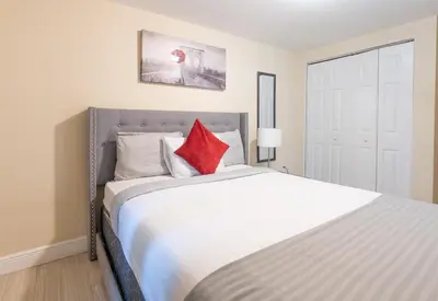 a bedroom with a large white bed with red pillows at COZY Private Apts in Hollywood By Hard Rock Casino! in Hollywood