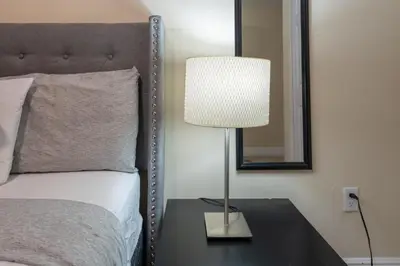 a lamp sitting on a table next to a bed at COZY Private Apts in Hollywood By Hard Rock Casino! in Hollywood