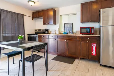 a kitchen with a table and a stainless steel refrigerator at COZY Private Apts in Hollywood By Hard Rock Casino! in Hollywood