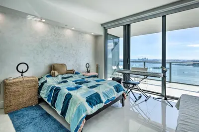 a bedroom with a bed and a desk and windows at Luxe Miami Condo with Community Pool and Hot Tub! in Miami