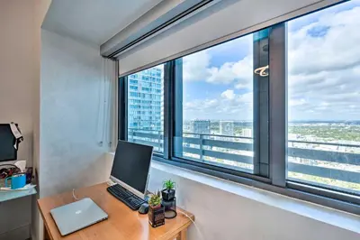 an office with a laptop computer on a desk in front of a window at Luxe Miami Condo with Community Pool and Hot Tub! in Miami