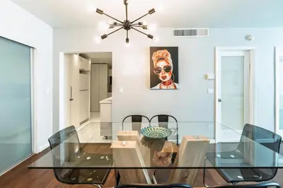 a dining room with a glass table and chairs at Dream Vacation Apartment Right On The Beach in Hollywood
