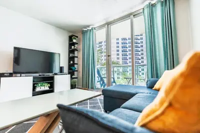a living room with a blue couch and a tv at Dream Vacation Apartment Right On The Beach in Hollywood