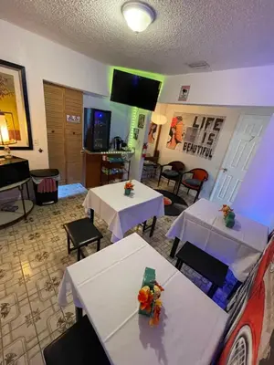 a dining room with two tables and a flat screen tv at Habitacion Centrica Calle 8 Miami (2) in Miami