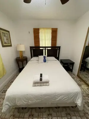 a bedroom with a bed with a cell phone on it at Habitacion Centrica Calle 8 Miami (2) in Miami