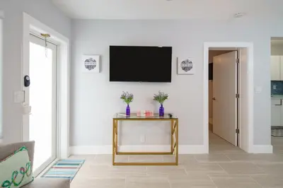 a living room with a tv on a wall at The Surf Hollywood Beach in Hollywood