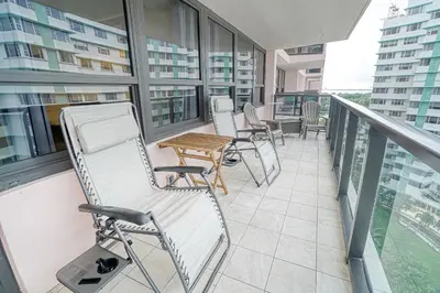 a balcony with chairs and a table on a building at Deluxe Apartments by South Florida Vacations in Miami Beach